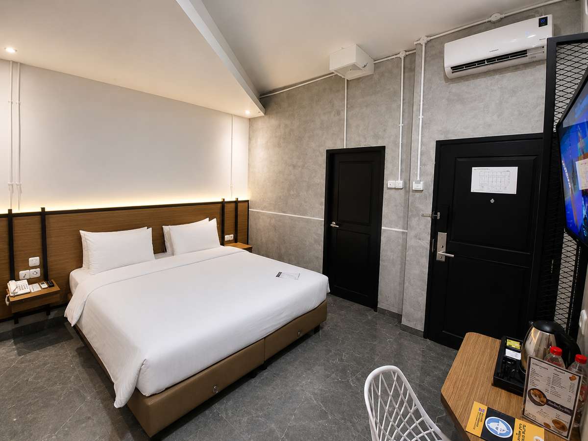 Deluxe Double Room dengan satu ranjang queen, televisi layar datar dan kamar mandi pribadi