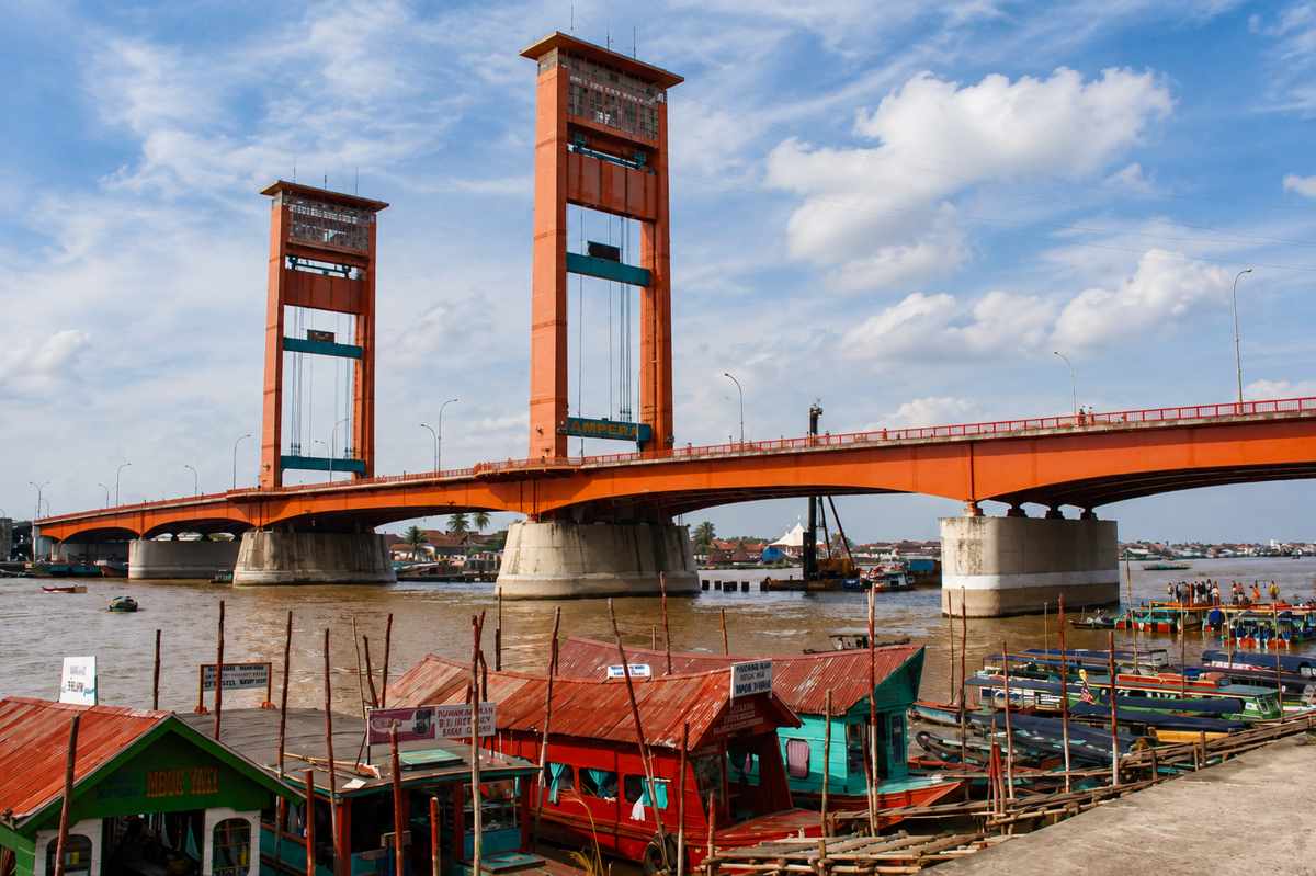 Jembatan Ampera yang melintasi Sungai Musi di Palembang dengan perahu di sepanjang tepian