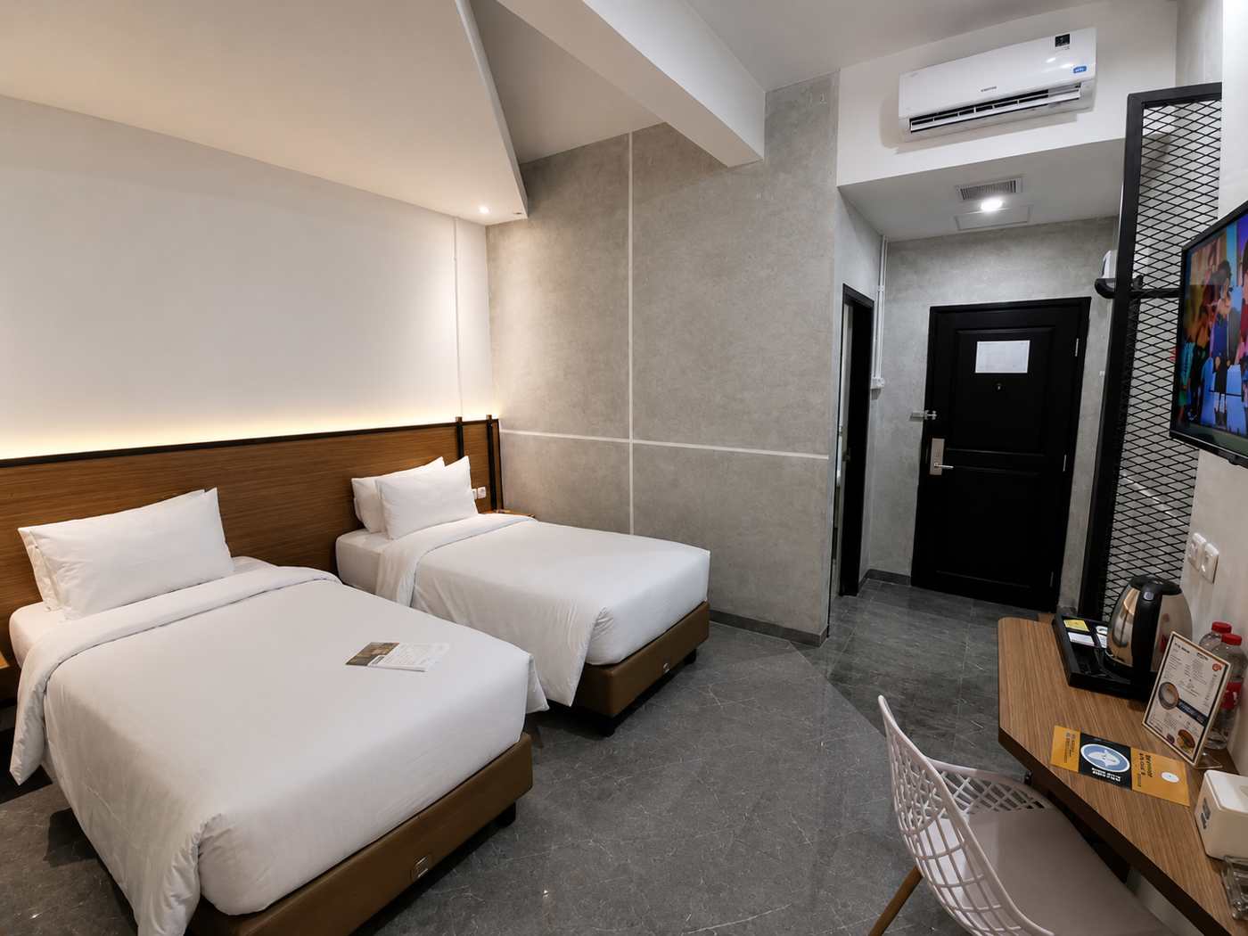 Deluxe Twin Room dengan dua tempat tidur single, pendingin udara, dan meja kerja